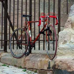 Vélo de course attaché à une grille dans une ruelle pavée - France  - collection de photos clin d'oeil, catégorie clindoeil